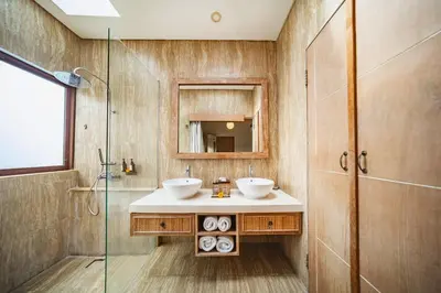 a bathroom with a sink and a glass shower at Azula Cozy Royal 2 BR Private Pool Villa With Jacuzzi in Legian