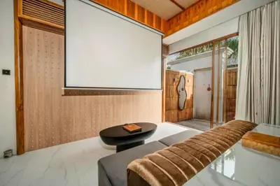 a living room with a large screen on the wall at Evelyn Grand 1 BR Private Pool Villa With Bathtub in Legian