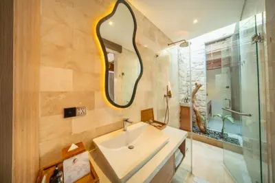a bathroom with a sink and a mirror at Evelyn Grand 1 BR Private Pool Villa With Bathtub in Legian