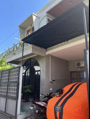 a motorcycle parked in front of a house at Bali Kiddy - Casa Fonte 3 BR in Denpasar