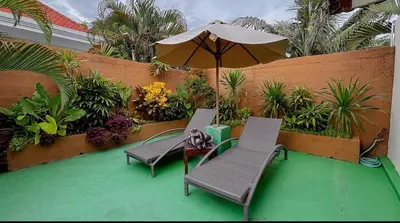 a patio with two chairs and an umbrella at New 2BR Mahaprada Private Pool in Seminyak in Seminyak