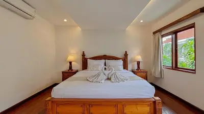 a bedroom with a bed with white sheets and two lamps at New 2BR Mahaprada Private Pool in Seminyak in Seminyak