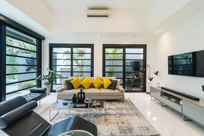 a living room with a couch and a tv at Modern 2BR Pool Villa in Umalas with Billiard & Long Pool in Canggu
