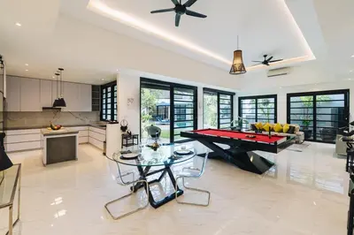 a living room with a pool table and a kitchen at Modern 2BR Pool Villa in Umalas with Billiard & Long Pool in Canggu