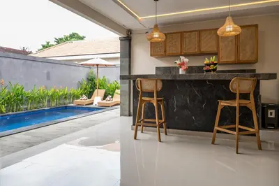 a kitchen with a bar and a swimming pool at Villa Inges 1 Seminyak in Seminyak