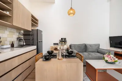 a kitchen and living room with a table and a couch at Sunset Max Villa in Seminyak