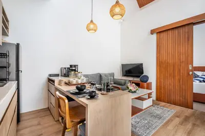 a kitchen with a wooden table in a room at Sunset Max Villa in Seminyak