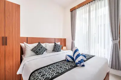 a bedroom with two beds and a window at Sunset Max Villa in Seminyak