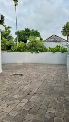 a white wall next to a brick patio at Villa Harmaka 2 in Kerobokan