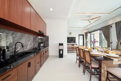 a kitchen and dining room with a table and chairs at Villa nia gray 1 in Seminyak