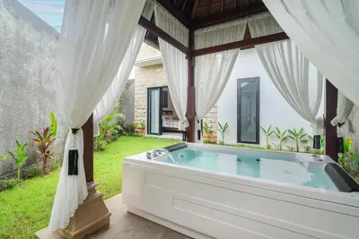 a bath tub in the backyard of a house at Villa nia gray 1 in Seminyak