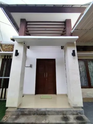 a small white building with a brown door at salah in Nusa Dua