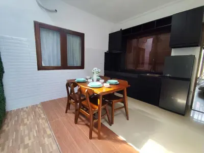 a kitchen with a wooden table and chairs in a room at salah in Nusa Dua
