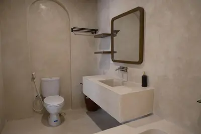 a bathroom with a sink and a toilet and a mirror at Avaya Boutique Hostel by Ayodya Beach Inn in Legian