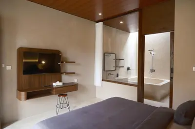 a bedroom with a bed and a tv and a tub at Avaya Boutique Hostel by Ayodya Beach Inn in Legian