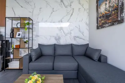 a living room with a couch and a marble wall at Casa Benita 2 Villa Seminyak in Seminyak