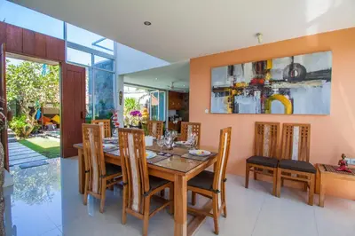 a dining room with a wooden table and chairs at Villa Efes Bali in Seminyak