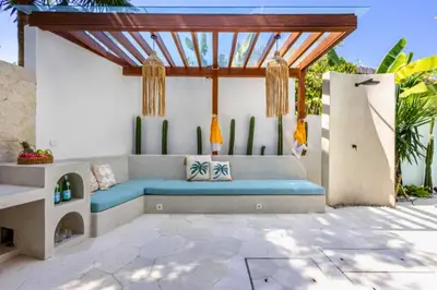 a patio with a blue couch under a pergola at Ashlyn Elegant 4 BR Private Pool Villa in Canggu