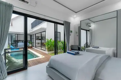 a bedroom with a bed and a swimming pool at Villa Paoua by BaliSuperHost in Seminyak