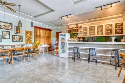 a restaurant with a table and chairs and a refrigerator at 3 Bd Pvt House with big common pool and Gym & BBQ in Nusa Dua
