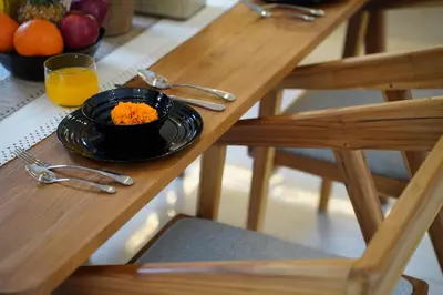 a plate of food on a wooden table with a glass of orange juice at 3 Bd Pvt House with big common pool and Gym & BBQ in Nusa Dua