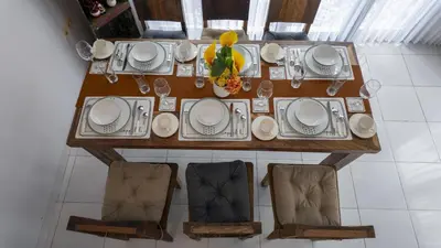 a table with plates and a vase of flowers on it at 3BR Private Pool Villa in Central Seminyak - Walk to Cafés & Shops in Seminyak