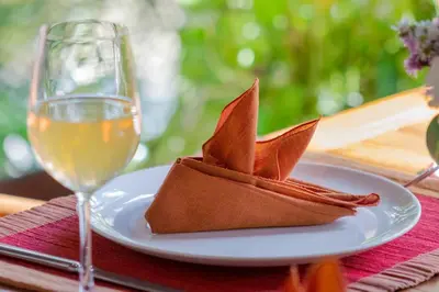 a plate with a napkin and a glass of wine at Heart of Seminyak, 2Br, Sleeps 4, Walk to Bintang in Seminyak