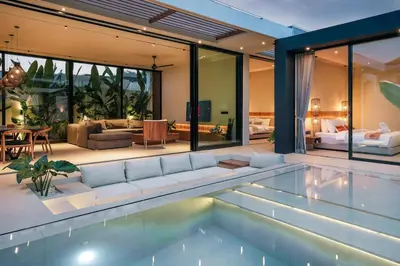 a house with a swimming pool and a living room at Villa Dorithis Umalas in Kerobokan