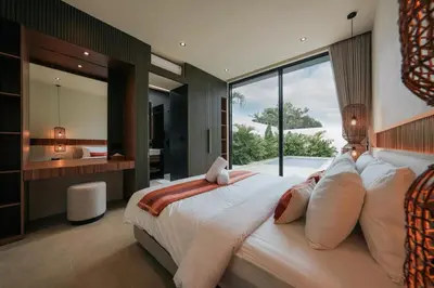 a bedroom with a large bed with a large window at Villa Dorithis Umalas in Kerobokan