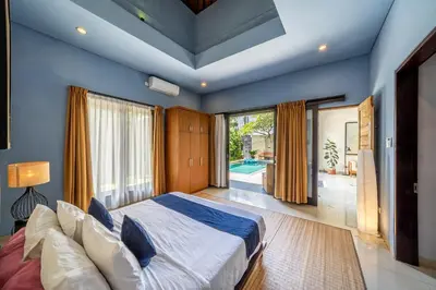 a bedroom with a large bed and a large window at Villa Tanaka Spacious Family Villa Berawa in Canggu