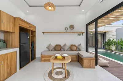 a kitchen and living room with a bed and a table at Nara V3 2BR Escape in the Heart of Seminyak in Seminyak