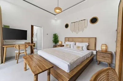 a bedroom with a bed and a desk and a television at Nara V3 2BR Escape in the Heart of Seminyak in Seminyak