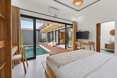 a bedroom with a large bed and a swimming pool at Nara V3 2BR Escape in the Heart of Seminyak in Seminyak