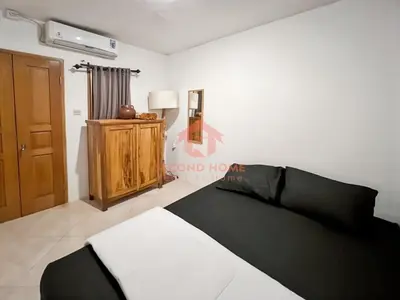 a bedroom with a black and white bed and a dresser at Strategic 2BR Seminyak House UP2 6 Person in Seminyak