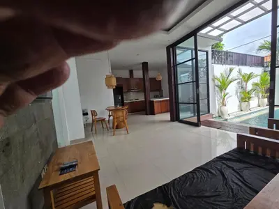 an open living room with a view of a house at Vila Hokyusa in Kerobokan