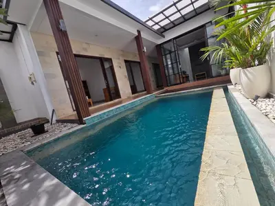a swimming pool in the middle of a house at Vila Hokyusa in Kerobokan
