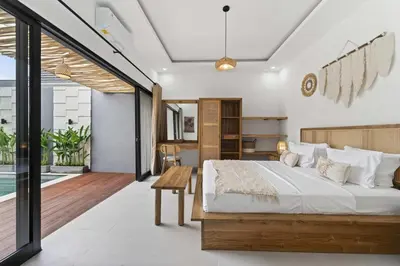a bedroom with a large bed and a balcony at Nara V11 2BR Escape in the Heart of Seminyak in Seminyak
