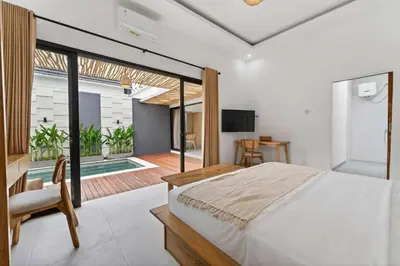 a bedroom with a bed and a sliding glass door at Nara V11 2BR Escape in the Heart of Seminyak in Seminyak