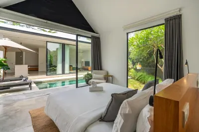 a bedroom with a bed and a large window at Villa Semilir Pagi, Canggu in Canggu