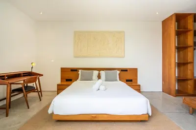a bedroom with a white bed and a desk at Villa Semilir Pagi, Canggu in Canggu