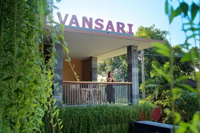 a woman standing on a balcony of a restaurant at Vansari Hotel in Seminyak