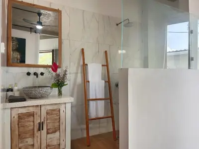 a bathroom with a sink and a mirror and a ladder at Uma 2 BR villa with Roof top pool & Enclosed living room in Seminyak