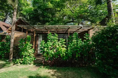 a small cabin with a door in the trees at Wow Cozy Lagoon! in Nusa Dua