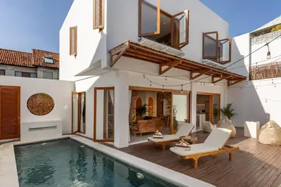 a villa with a swimming pool and a house at Luxury 3BR Canggu | Billiards | Outdoor Cinema in Canggu