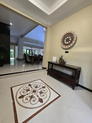 a living room with a table and a rug on the floor at Happy's house Bali in Kerobokan