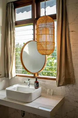 a bathroom sink with a mirror and a chandelier at Tropical 3BR Oasis w Private Pool Villa Nau Mai in Seminyak