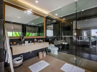 a bathroom with a toilet and a glass shower at villa dreamland beach 300 meter private walk in Jimbaran