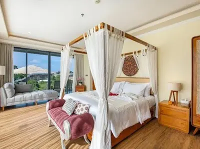 a bedroom with a canopy bed and a couch at villa dreamland beach 300 meter private walk in Jimbaran