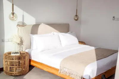 a bedroom with a bed with white sheets and a table at Villa Kenia 1 in Umalas, near Canggu in Canggu