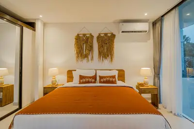 a bedroom with a bed and two lamps and a window at Villa Orchid Heaven by Bali Villa Solutions in Seminyak